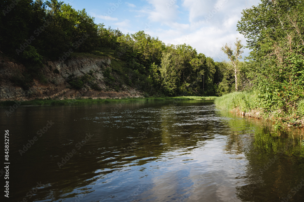 The serene river landscape with greenery, trees, and a clear blue sky exudes calm and tranquility, reflecting natures beauty and peacefulness in a picturesque scene The serene river landscape with greenery, trees, and a clear blue sky exudes calm and tranquility, reflecting natures beauty and peacefulness in a picturesque scene