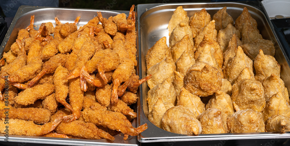 Fried shrimp, breaded prawns and fried crispy dumplings. Golden brown samosas ready to eat Fried shrimp, breaded prawns and fried crispy dumplings. Golden brown samosas ready to eat
