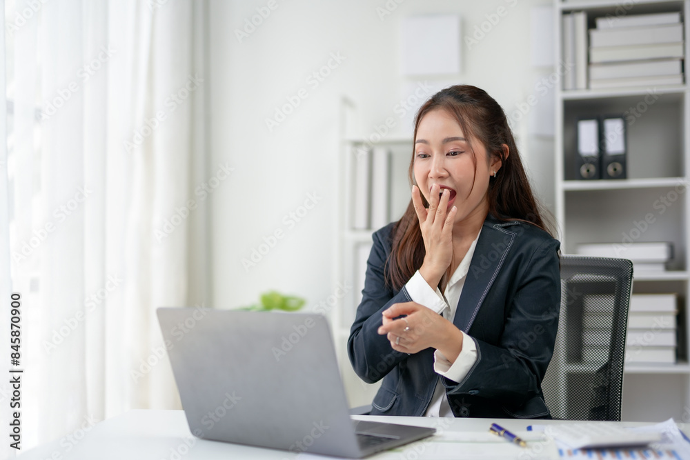 Businesswoman in office surprised by news on laptop. Modern office setting with natural light and organized workspace. Businesswoman in office surprised by news on laptop. Modern office setting with natural light and organized workspace.
