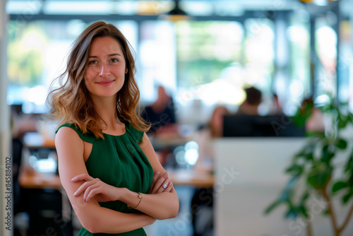 Smiling Woman in Modern Office Setting. A smiling woman in a green dress stands confidently in a modern office setting, embodying professionalism and positivity. Free Download Smiling Woman in Modern Office Setting. A smiling woman in a green dress stands confidently in a modern office setting, embodying professionalism and positivity. - GFXLoad