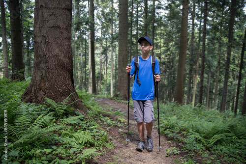 A guy walks along a path in the forest.
