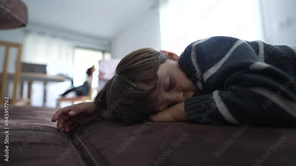 Close-Up of Child Napping on Sofa, Head Resting on Hand, Wearing Striped Sweater, Enjoying Quiet Afternoon Rest Close-Up of Child Napping on Sofa, Head Resting on Hand, Wearing Striped Sweater, Enjoying Quiet Afternoon Rest