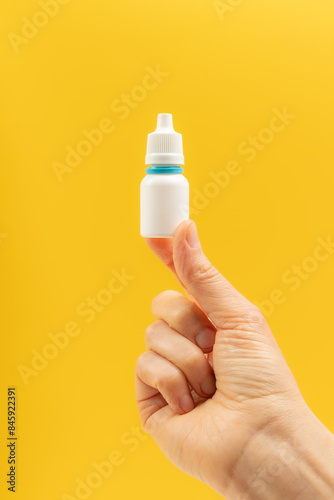 Hand holding a white plastic medicine bottle