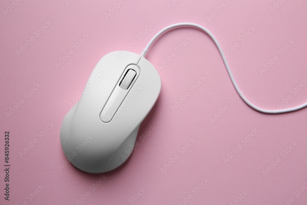 One wired mouse on pink background, top view One wired mouse on pink background, top view