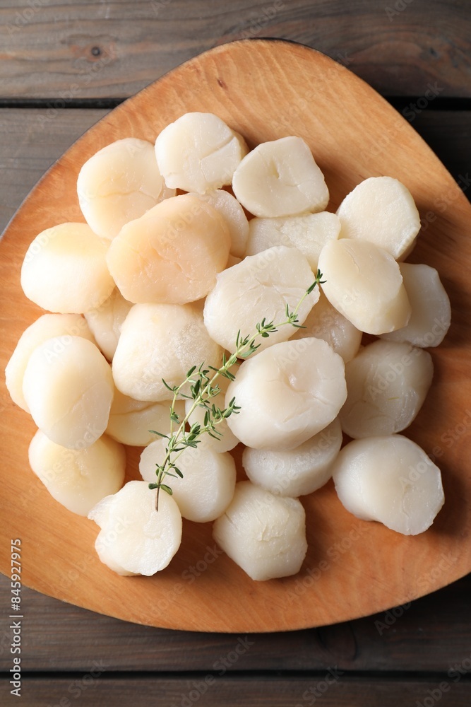 Fresh raw scallops and thyme on wooden table, top view Fresh raw scallops and thyme on wooden table, top view