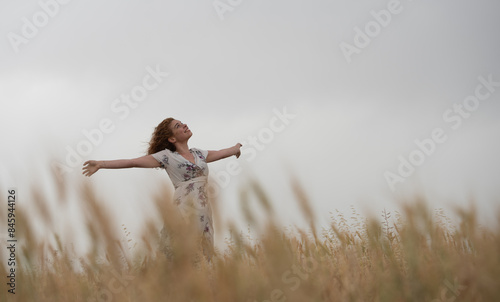 Joyful woman embracing nature in wheat field
