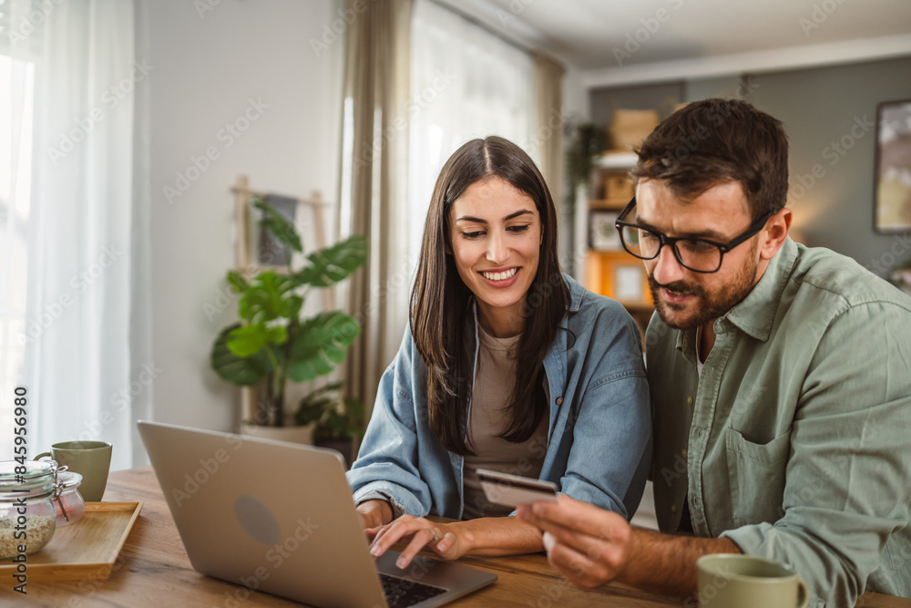 Boyfriend and girlfriend buy online on laptop with credit card at home Boyfriend and girlfriend buy online on laptop with credit card at home