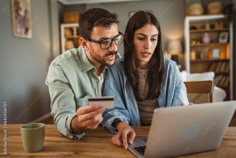 Boyfriend and girlfriend buy online on laptop with credit card at home Boyfriend and girlfriend buy online on laptop with credit card at home