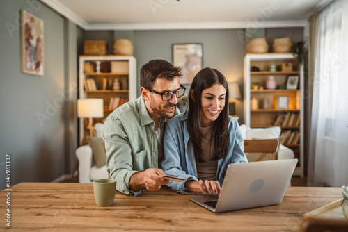 Boyfriend and girlfriend buy online on laptop with credit card at home