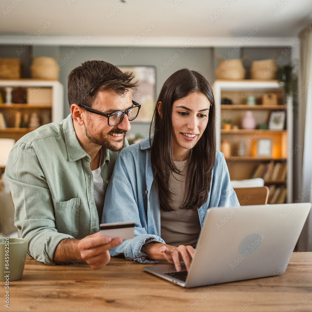 Fototapeta premium Boyfriend and girlfriend buy online on laptop with credit card at home