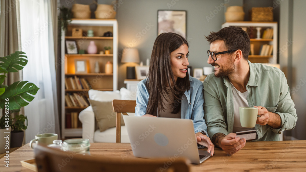 Boyfriend and girlfriend buy online on laptop with credit card at home Boyfriend and girlfriend buy online on laptop with credit card at home