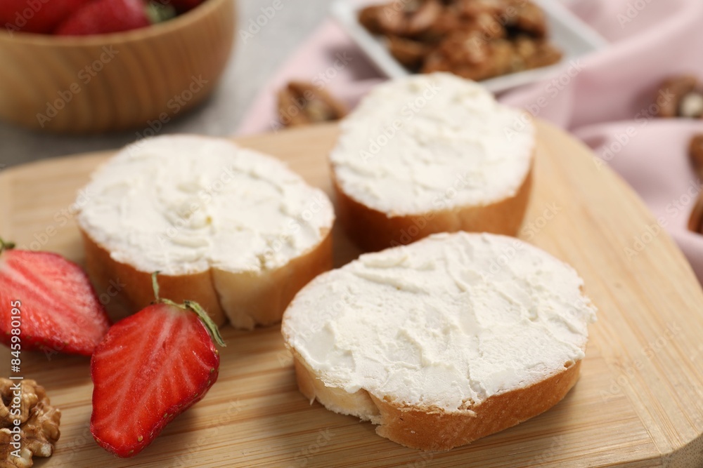 Delicious bruschettas with ricotta cheese, strawberries and walnuts on table, closeup Delicious bruschettas with ricotta cheese, strawberries and walnuts on table, closeup