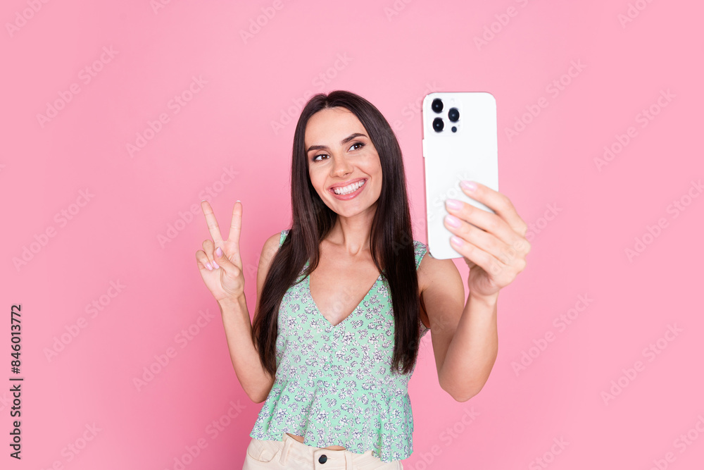 Photo of lovely pretty adorable woman stylish clothes streaming recording video v-sign isolated on pink color background Photo of lovely pretty adorable woman stylish clothes streaming recording video v-sign isolated on pink color background