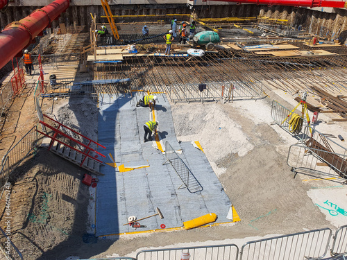 Photography Construction site with large basement excavation, structural waterproofing, temporary works, capping beams, contiguous pile walls, and heavy machinery