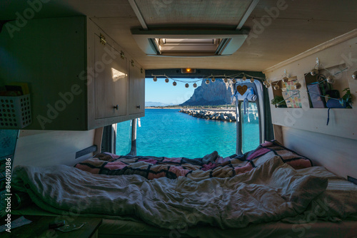 View out of a self built camper van at coast of the mediterranean sea with view at turquoise bay and Monte Monaco, San Vito Lo Capo, Sicily, Italy photo