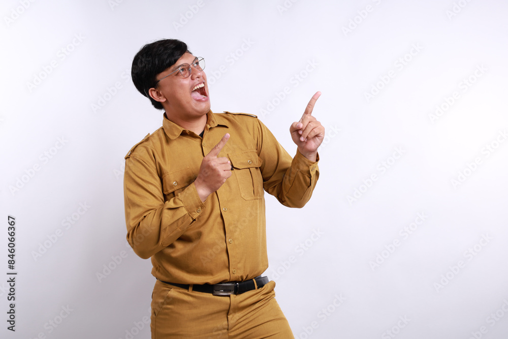 Happy Indonesian government employees standing while presenting sideways on blank space Happy Indonesian government employees standing while presenting sideways on blank space