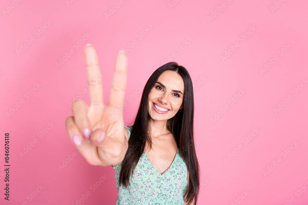 Photo of lovely cheerful good mood woman wear stylish clothes demonstrate v-sign isolated on pink color background