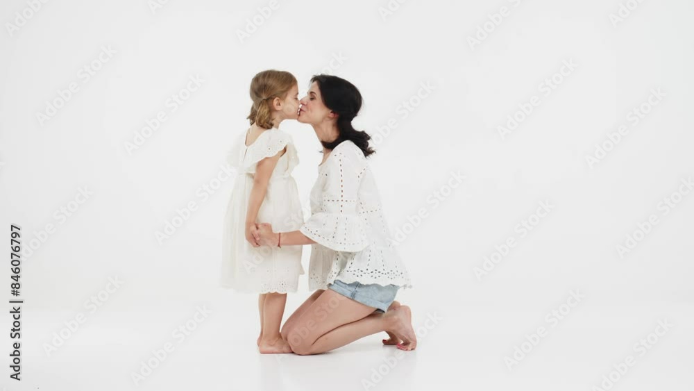 Family relationships between mother and daughter. Sensual mother with her little daughter on a light studio background. Tender moment, family support. Family relationships between mother and daughter. Sensual mother with her little daughter on a light studio background. Tender moment, family support.