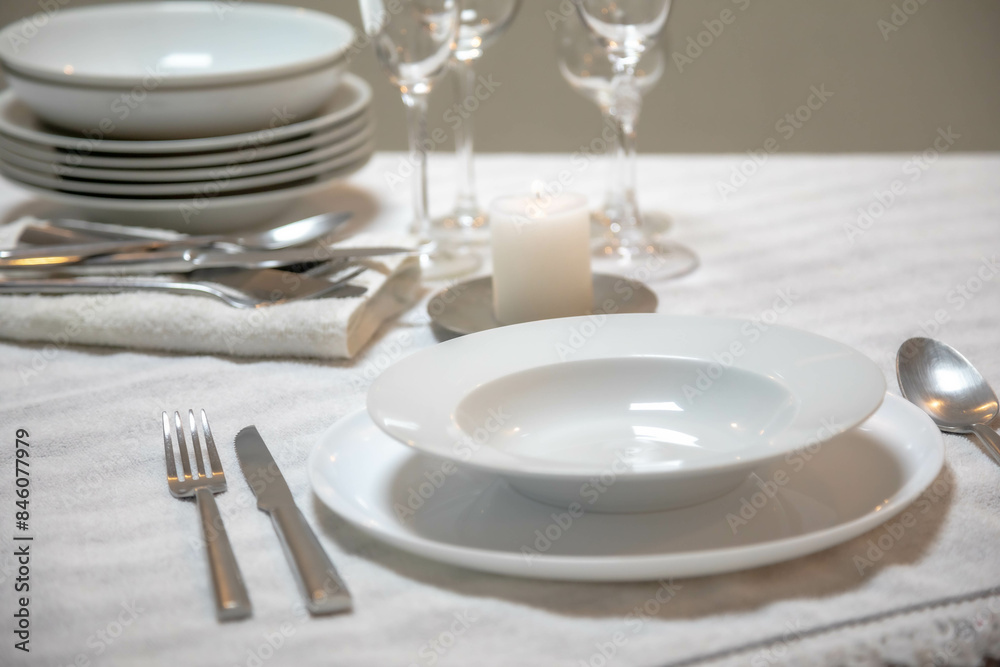 Luxurious table setting with white plates, crystal glasses and fine cutlery