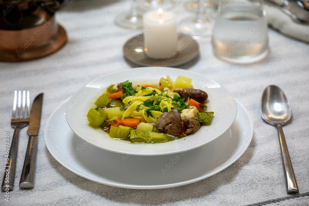 Luxurious table setting with white plates, crystal glasses and fine cutlery. Soup Luxurious table setting with white plates, crystal glasses and fine cutlery. Soup