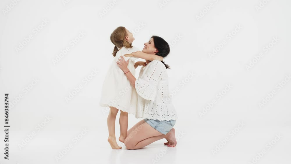 Family relationships between mother and daughter. Sensual mother with her little daughter on a light studio background. Tender moment, family support. Family relationships between mother and daughter. Sensual mother with her little daughter on a light studio background. Tender moment, family support.