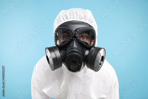 Worker in gas mask on light blue background © New Africa