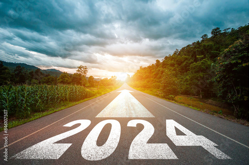 New year 2024 or straight forward concept. Text 2024 written on the road in the middle of asphalt road with at sunset. Concept of planning, goal, challenge, new year resolution..