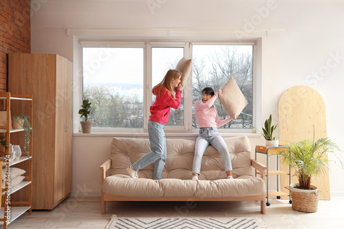Young women fighting cushio...