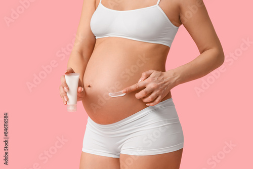 Young pregnant woman applyi...
