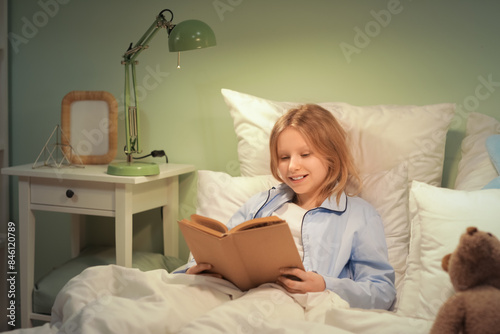 Adorable girl reading fairy...