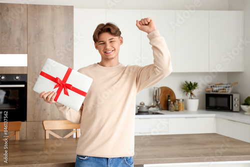Young man with gift laptop ...