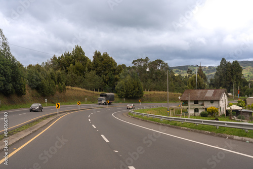 Curve on a highway with a house in the Colombian countryside.