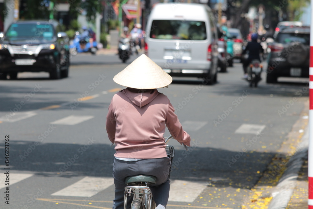 A woman riding a bicycle in Vietnam A woman riding a bicycle in Vietnam