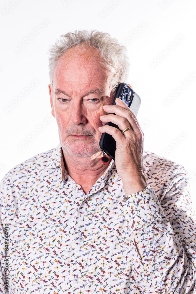 An elderly man is deeply engrossed in a phone conversation, his outfit adorned with a vibrant and intricate pattern An elderly man is deeply engrossed in a phone conversation, his outfit adorned with a vibrant and intricate pattern
