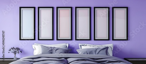 A chic bedroom with a lavender wall, showcasing six empty black frames in an irregular grid. photo