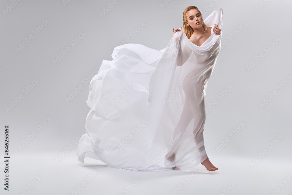 Young nude woman dancing with white veil in her hands Young nude woman dancing with white veil in her hands