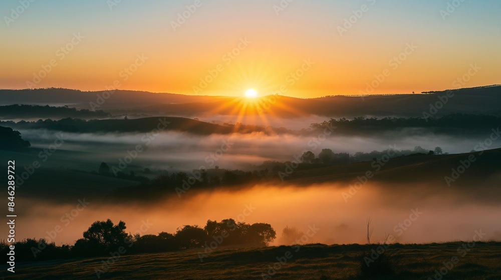 Fototapeta premium A beautiful sunrise over a misty valley.