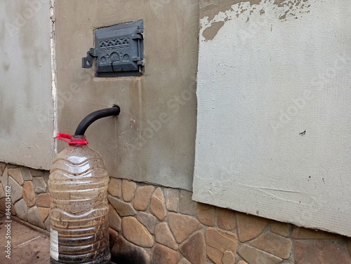 Near the wall of the rear boiler room, a hose is placed for removing condensate from the chimney during heating of the house in the winter season. The topic of heating installation and maintenance of 