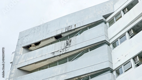 Old building facade, run down house exterior, Ceilings damaged by moisture. Detail of old residential flat apartment building exterior. Facade of the building. Damaged roof with hole in ceiling. moldy photo