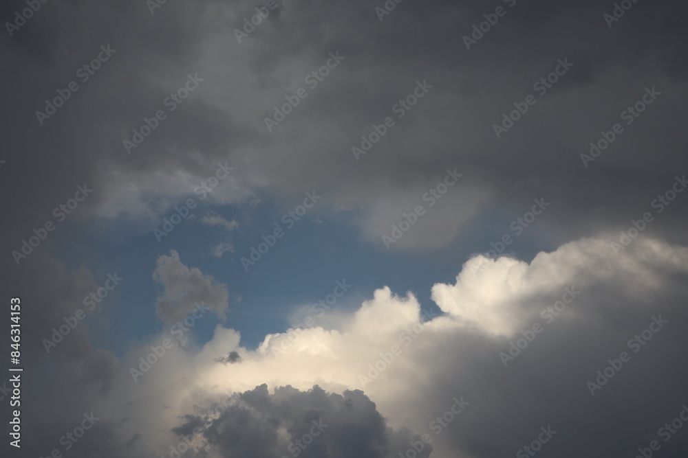 Dramatic sky with dark clouds and sunlit patches creates striking contrast in weather Dramatic sky with dark clouds and sunlit patches creates striking contrast in weather
