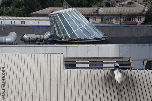 The industrial building features a roof made of glass, along with ventilation pipes photo