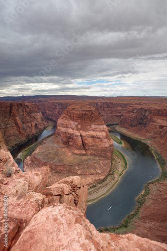 Standing on the steep edge of Horseshoe bend canyon, looking down at Colorado river