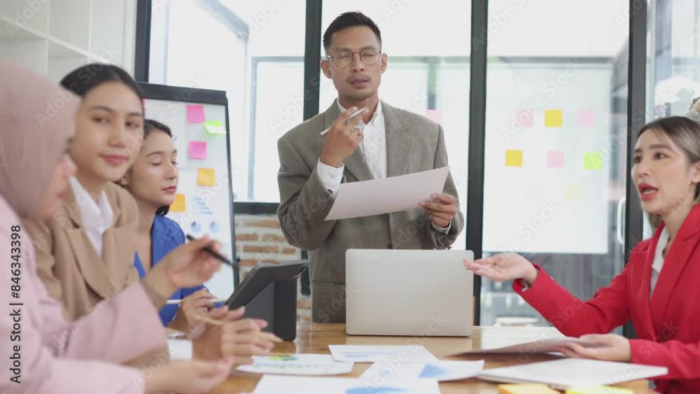 Asian group of people working with documents have financial or marketing charts on a board room table at a business presentation or seminar, business training meeting concept. Asian group of people working with documents have financial or marketing charts on a board room table at a business presentation or seminar, business training meeting concept.