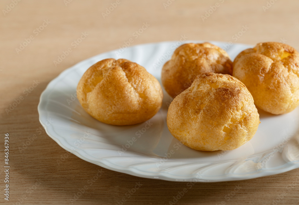 Cream puffs placed on a plate at the table. Cream puffs placed on a plate at the table.