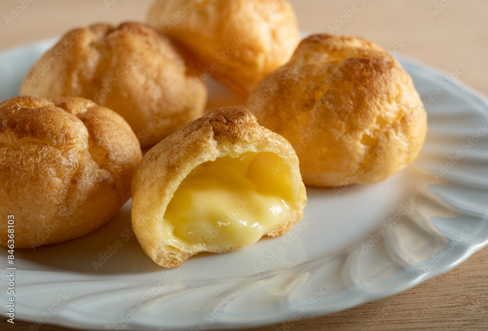 Cream puffs placed on a plate at the table. Cream puffs placed on a plate at the table.