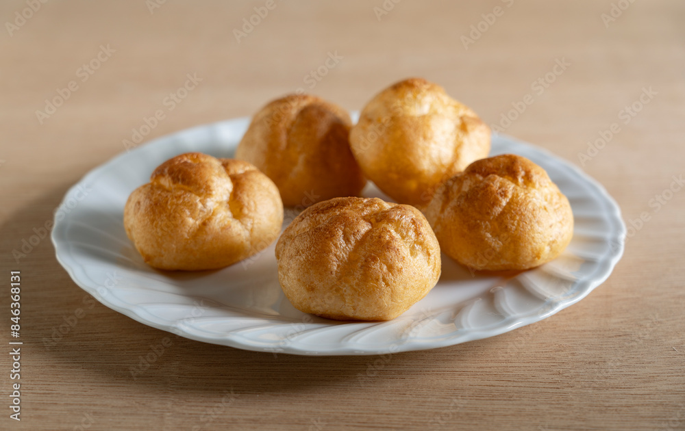 Cream puffs placed on a plate at the table.