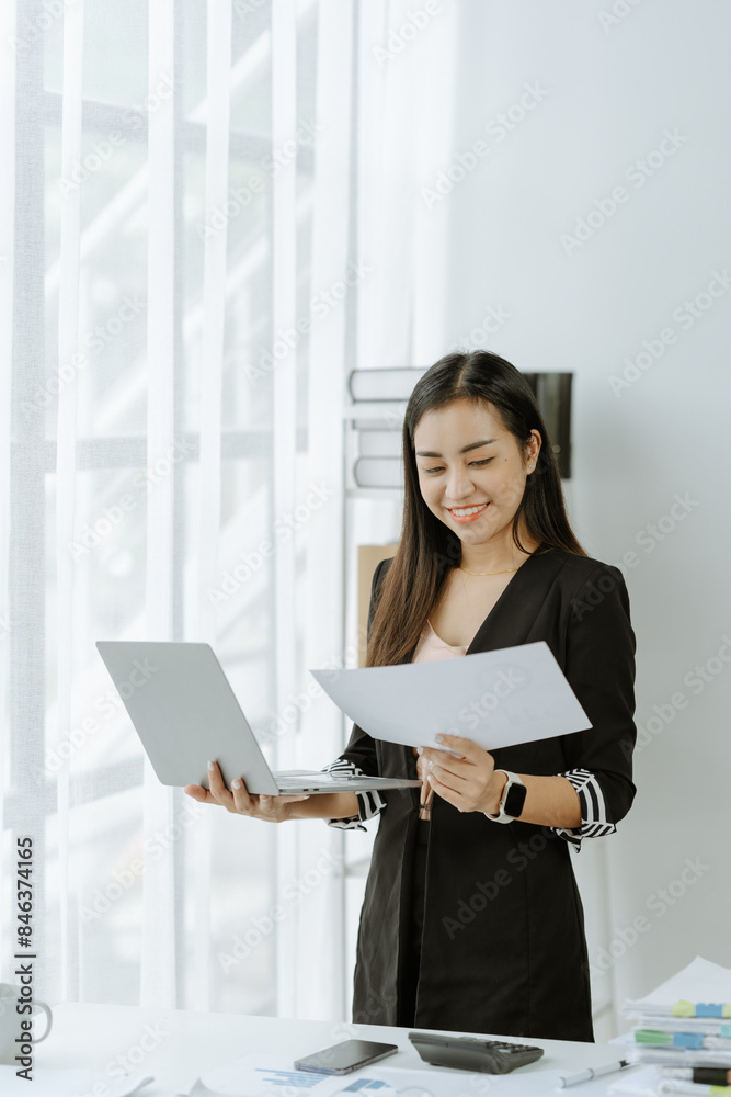 Asian Businesswoman Using laptop computer and working at office with calculator document on desk, doing planning analyzing the financial report, Asian Businesswoman Using laptop computer and working at office with calculator document on desk, doing planning analyzing the financial report,