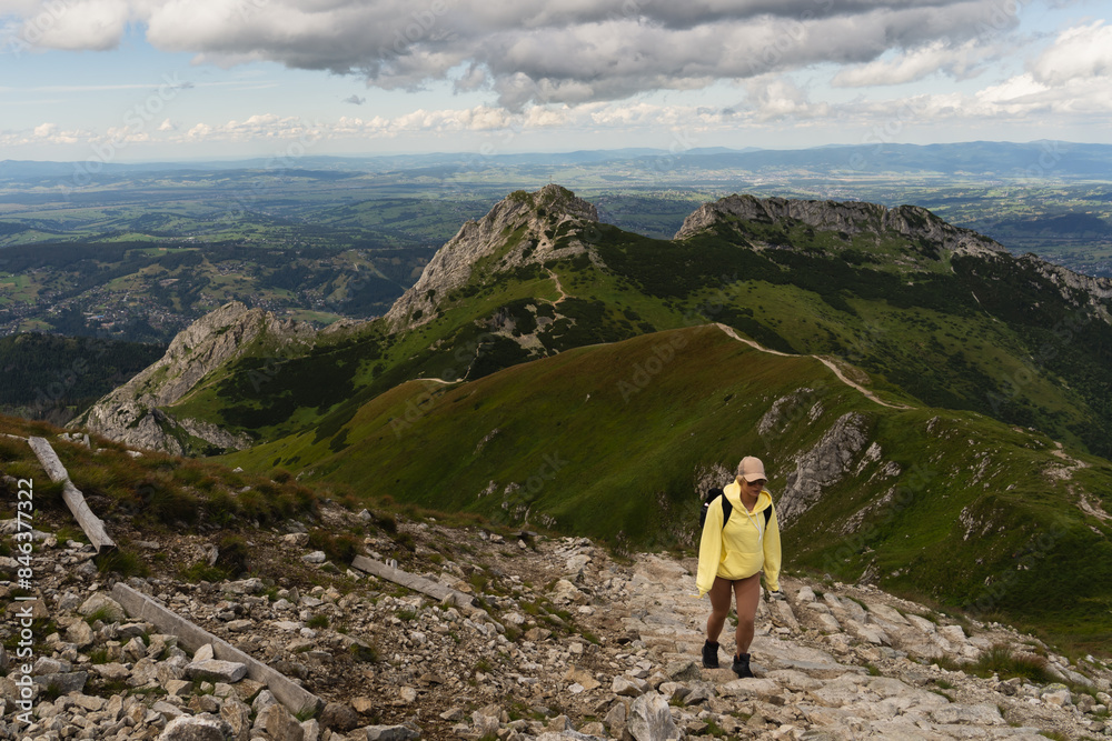A girl of European appearance is a traveler on the top of the Polish Tatra Mountains on a summer day. A girl of European appearance is a traveler on the top of the Polish Tatra Mountains on a summer day.