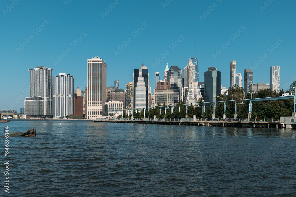 Naklejka premium Scenic view of New York City skyline from the waterfront on a sunny day