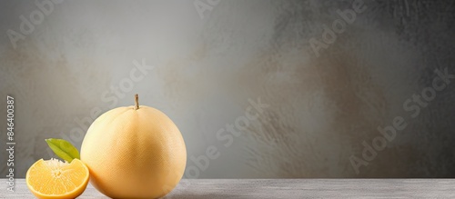 A copy space image of a ripe pomelo placed on a smooth gray cement background perfect for celebrating the Mid Autumn Festival with a fruity treat